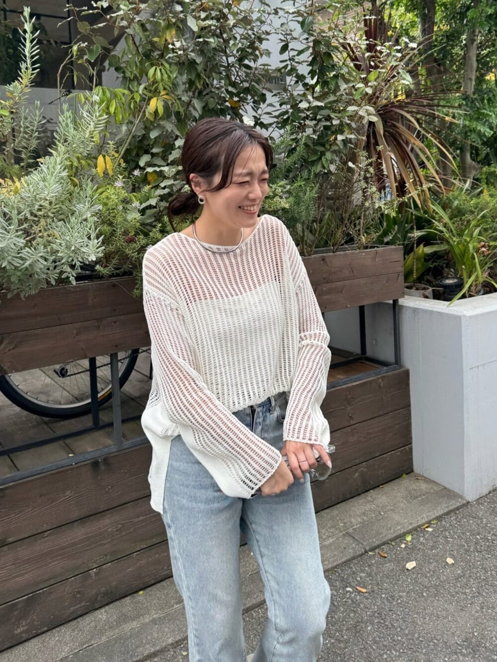 ホワイト系のニット/セーター、ブルー系のデニムパンツ、グレー系のサンダルを着用したレディースの春コーディネートの4枚目の写真