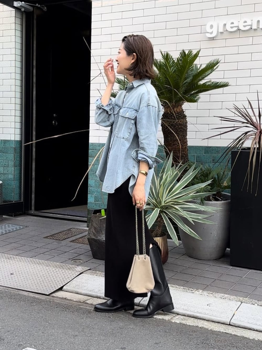 ブルー系のシャツ/ブラウス、ブラック系のスカート、ベージュ系のショルダーバッグを着用したレディースの冬コーディネートの3枚目の写真