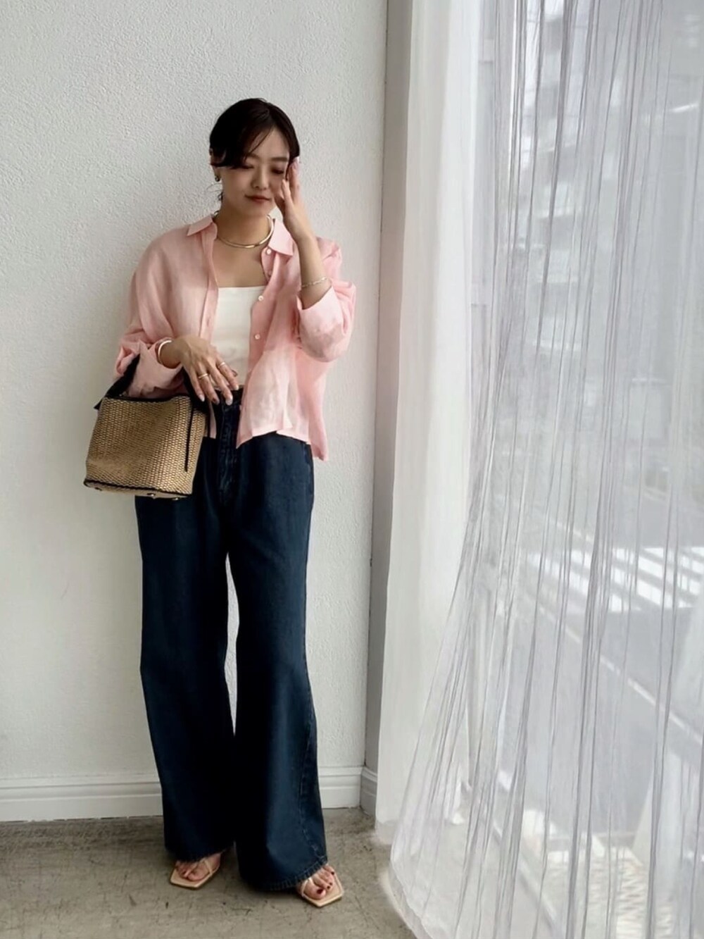 ピンク系のシャツ/ブラウス、ホワイト系のキャミソール、ブルー系のデニムパンツを着用したレディースの春コーディネートの2枚目の写真