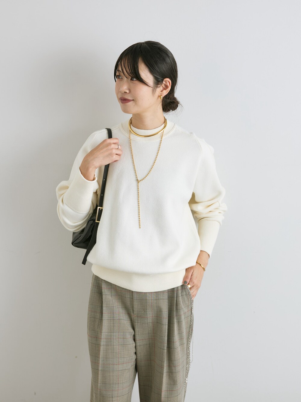 ホワイト系のニット/セーター、ブラック系のショルダーバッグ、ベージュ系のその他パンツを着用したレディースの秋コーディネートの4枚目の写真