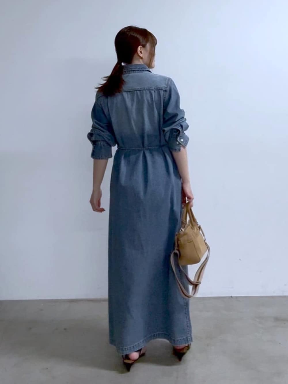 ベージュ系のトートバッグ、ブラック系のサンダル、ブルー系のワンピースを着用したレディースの春コーディネートの3枚目の写真