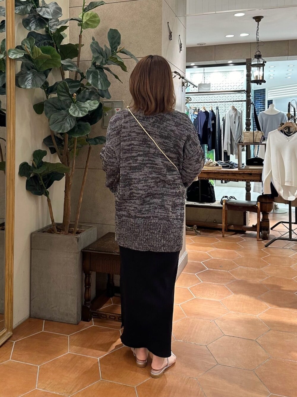 グレー系のカーディガン/ボレロ、ブラック系のワンピース、シルバー系のサンダルを着用したレディースの春コーディネートの3枚目の写真