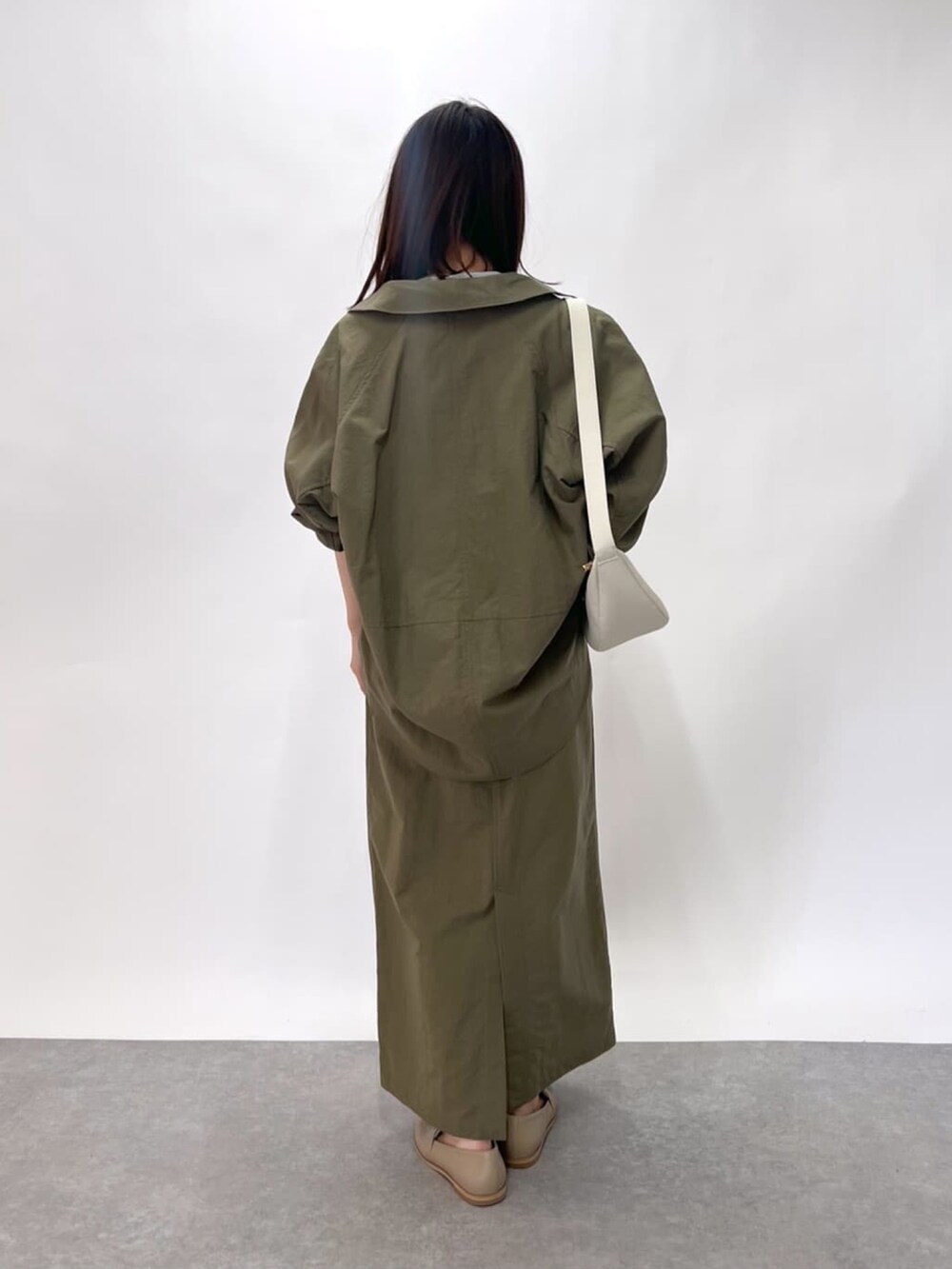 ホワイト系のニット/セーター、グリーン系のシャツ/ブラウス、グリーン系のスカートを着用したレディースの春コーディネートの4枚目の写真