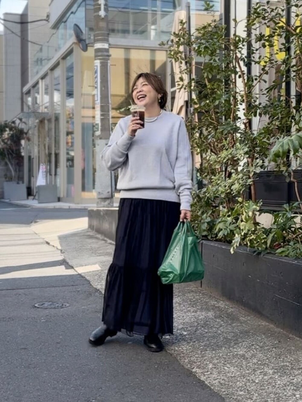 ホワイト系のニット/セーター、ブラック系のスカート、ブラック系のブーツを着用したレディースの冬コーディネートの2枚目の写真