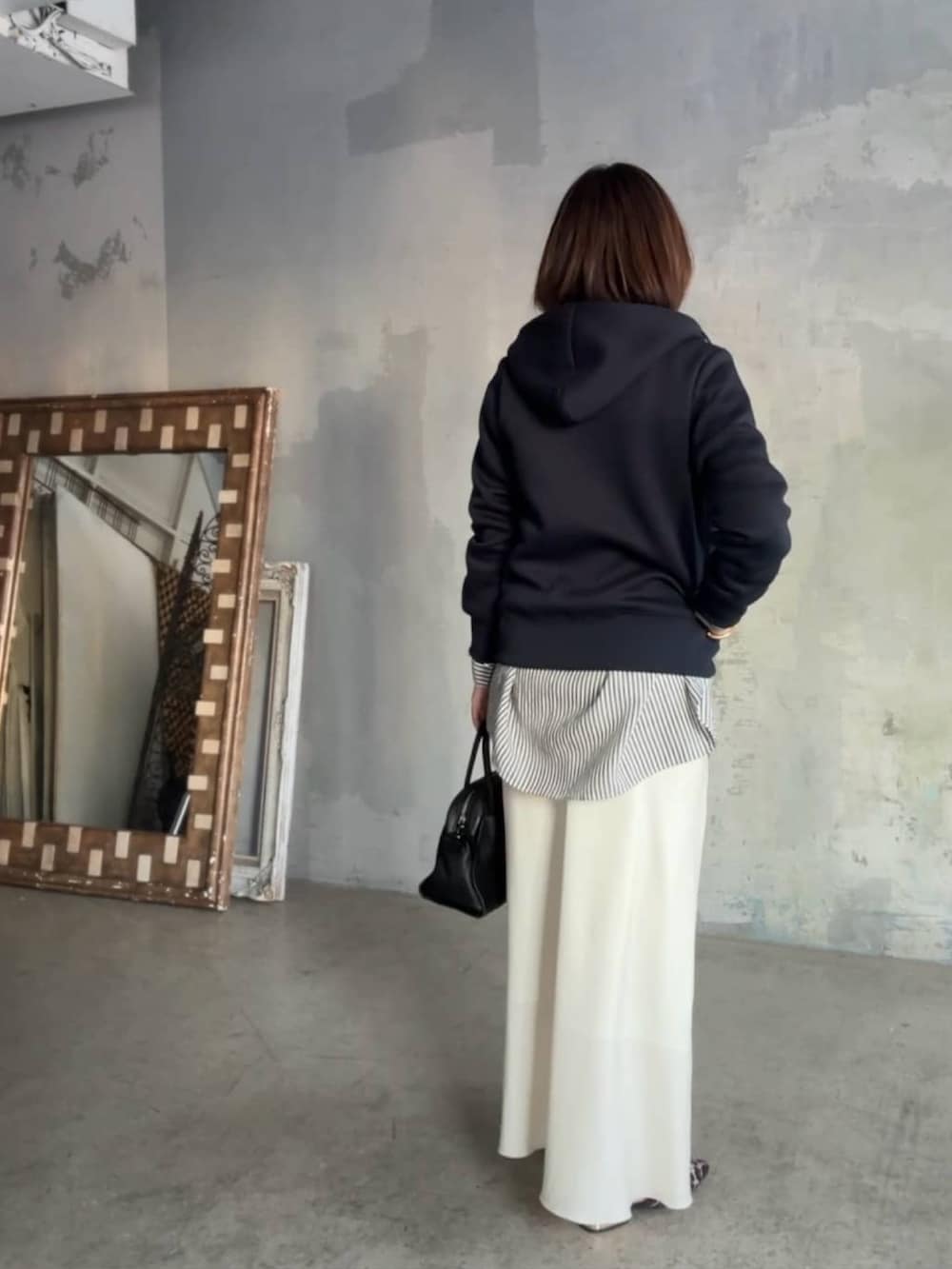 ブルー系のパーカー、ホワイト系のシャツ/ブラウス、ブラック系のボストンバッグを着用したレディースの冬コーディネートの3枚目の写真