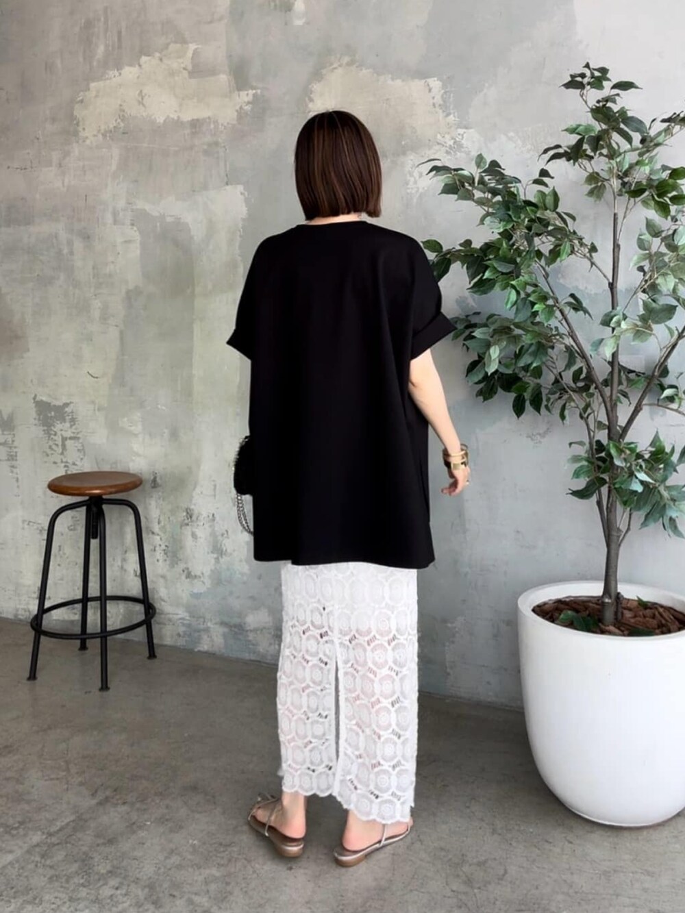 ブラック系のTシャツ/カットソー、ブラック系のショルダーバッグ、ホワイト系のスカートを着用したレディースの夏コーディネートの3枚目の写真