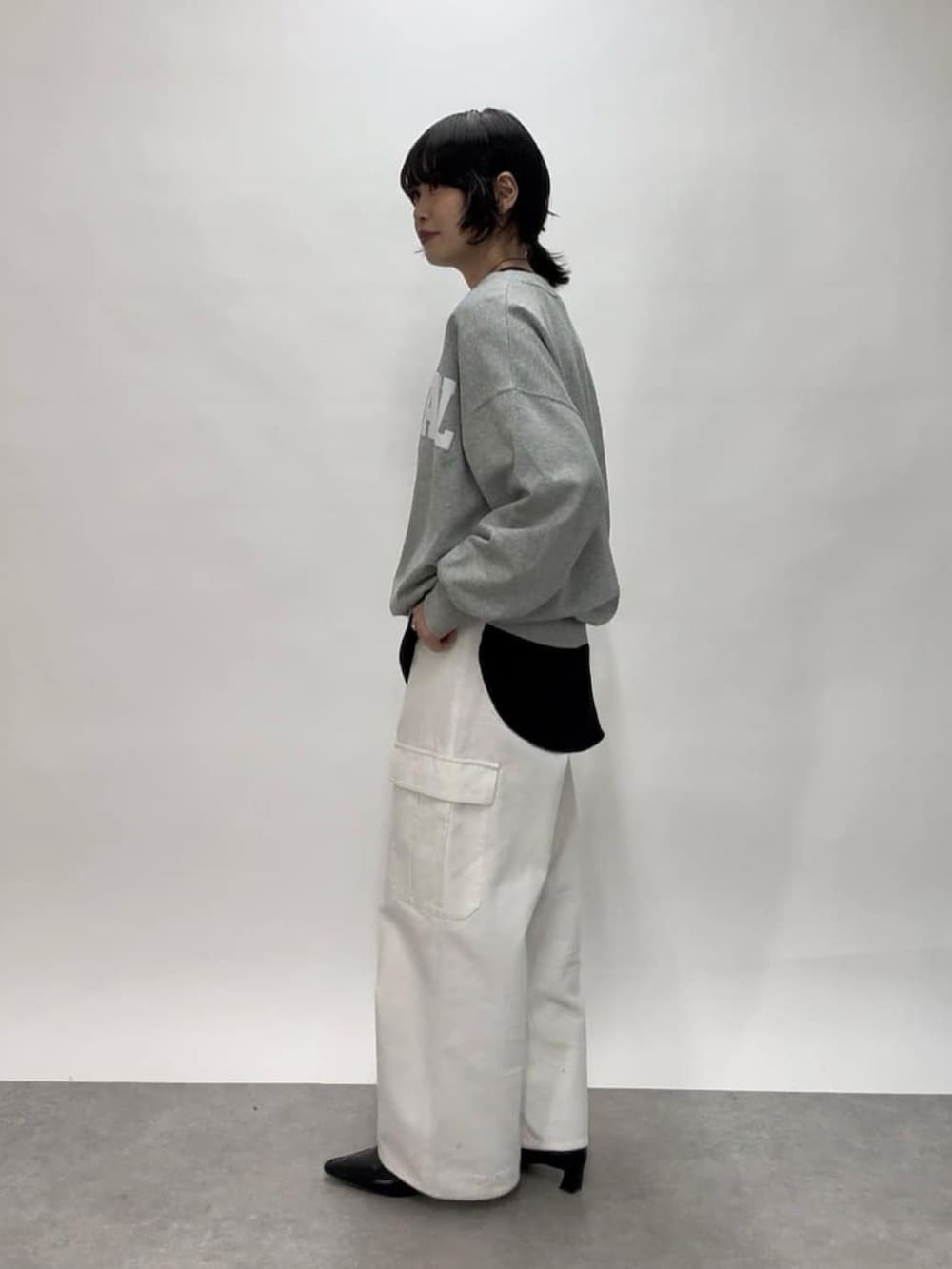 ホワイト系のカーゴパンツ、ブラック系のショルダーバッグ、ブラック系のローファーを着用したレディースの冬コーディネートの2枚目の写真