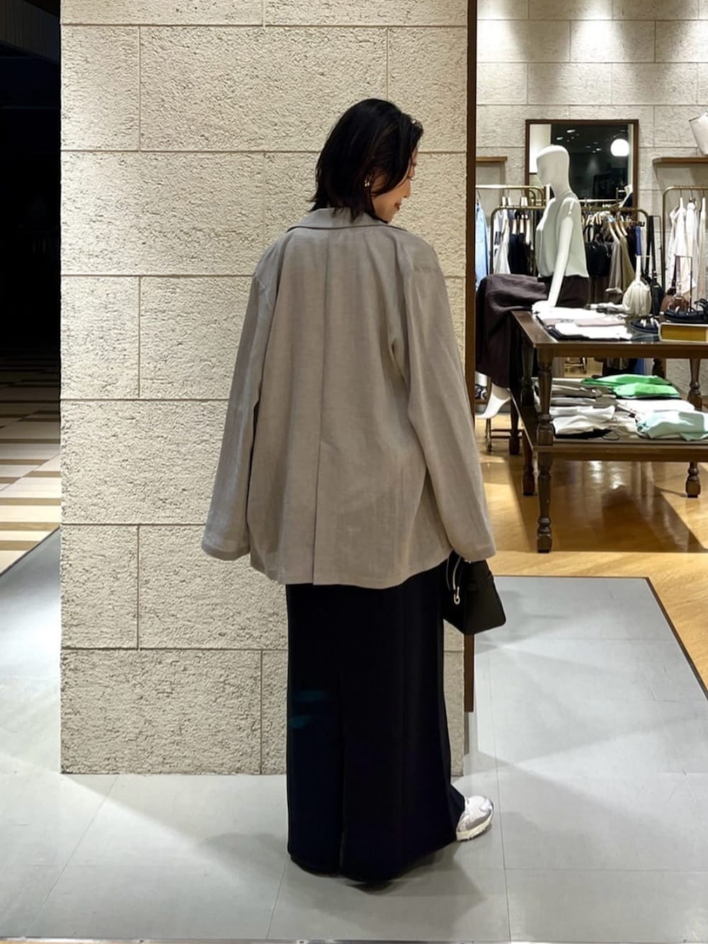 グレー系のテーラードジャケット、ホワイト系のTシャツ/カットソー、ブラック系のスカートを着用したレディースの夏コーディネートの3枚目の写真