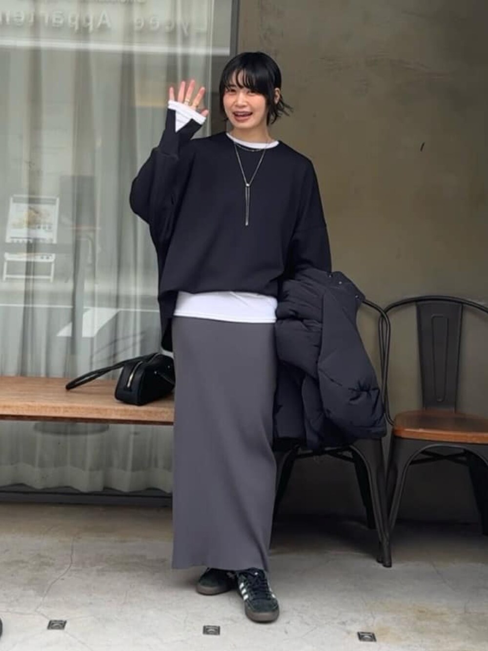 ブラック系のTシャツ/カットソー、グレー系のスカート、ホワイト系のTシャツ/カットソーを着用したレディースの冬コーディネートの2枚目の写真