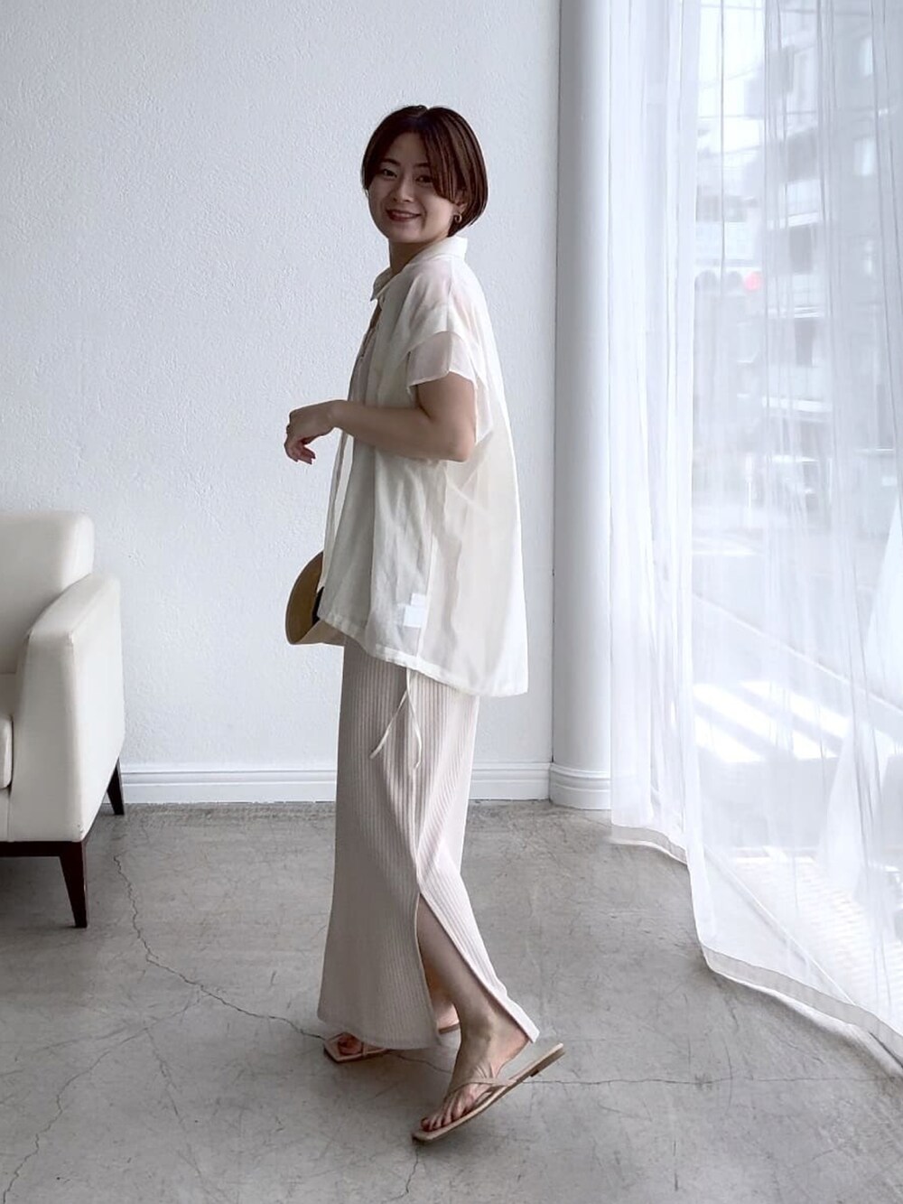 ホワイト系のワンピース、イエロー系のサンダル、ホワイト系のシャツ/ブラウスを着用したレディースの春コーディネートの2枚目の写真