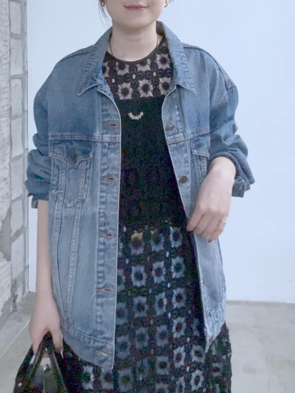 ブルー系のデニムジャケット、ブラック系のその他シューズ、ブラック系のボストンバッグを着用したレディースの冬コーディネートの3枚目の写真