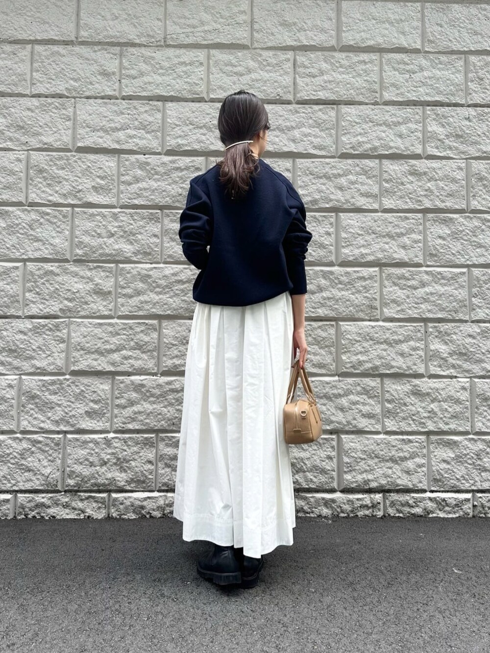 ホワイト系のスカート、ブルー系のニット/セーター、ブラック系のブーツを着用したレディースの秋コーディネートの4枚目の写真