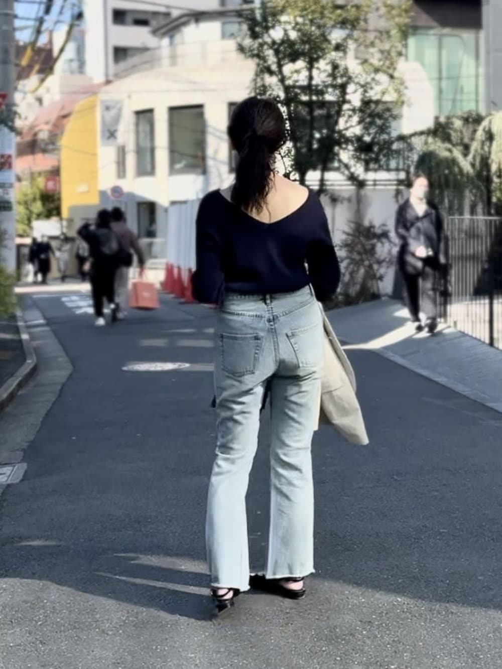 ブルー系のニット/セーター、ブルー系のデニムパンツ、ブラック系のパンプスを着用したレディースの冬コーディネートの3枚目の写真