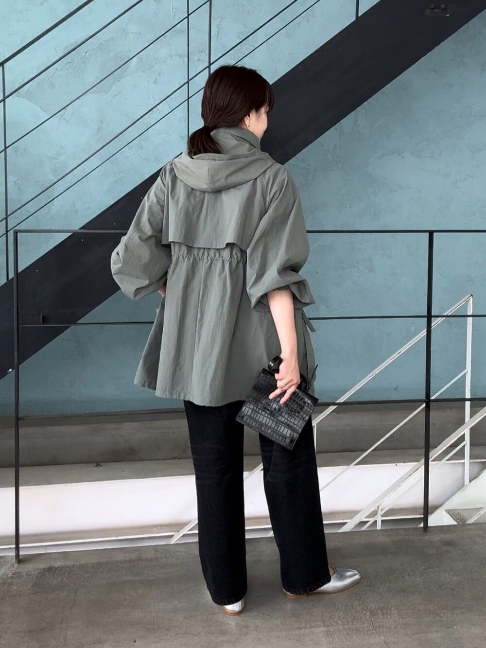 グリーン系のマウンテンパーカー、ブラック系のデニムパンツを着用したレディースの夏コーディネートの4枚目の写真