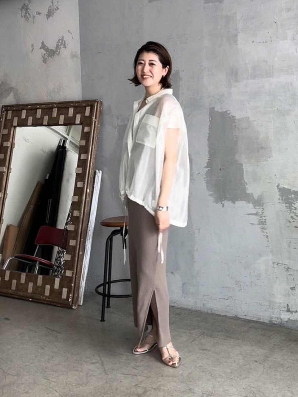 グリーン系のワンピース、シルバー系のサンダル、ホワイト系のシャツ/ブラウスを着用したレディースの春コーディネートの2枚目の写真