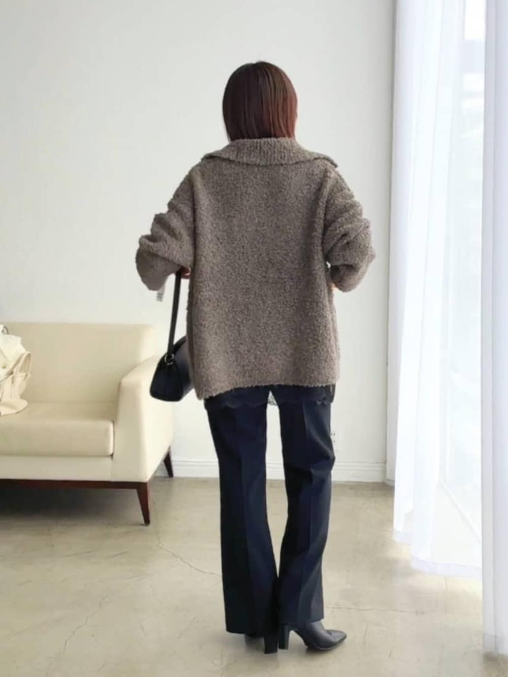 ブラック系のブーツ、ブラック系のキャミソール、ブラウン系のその他アウターを着用したレディースの冬コーディネートの3枚目の写真