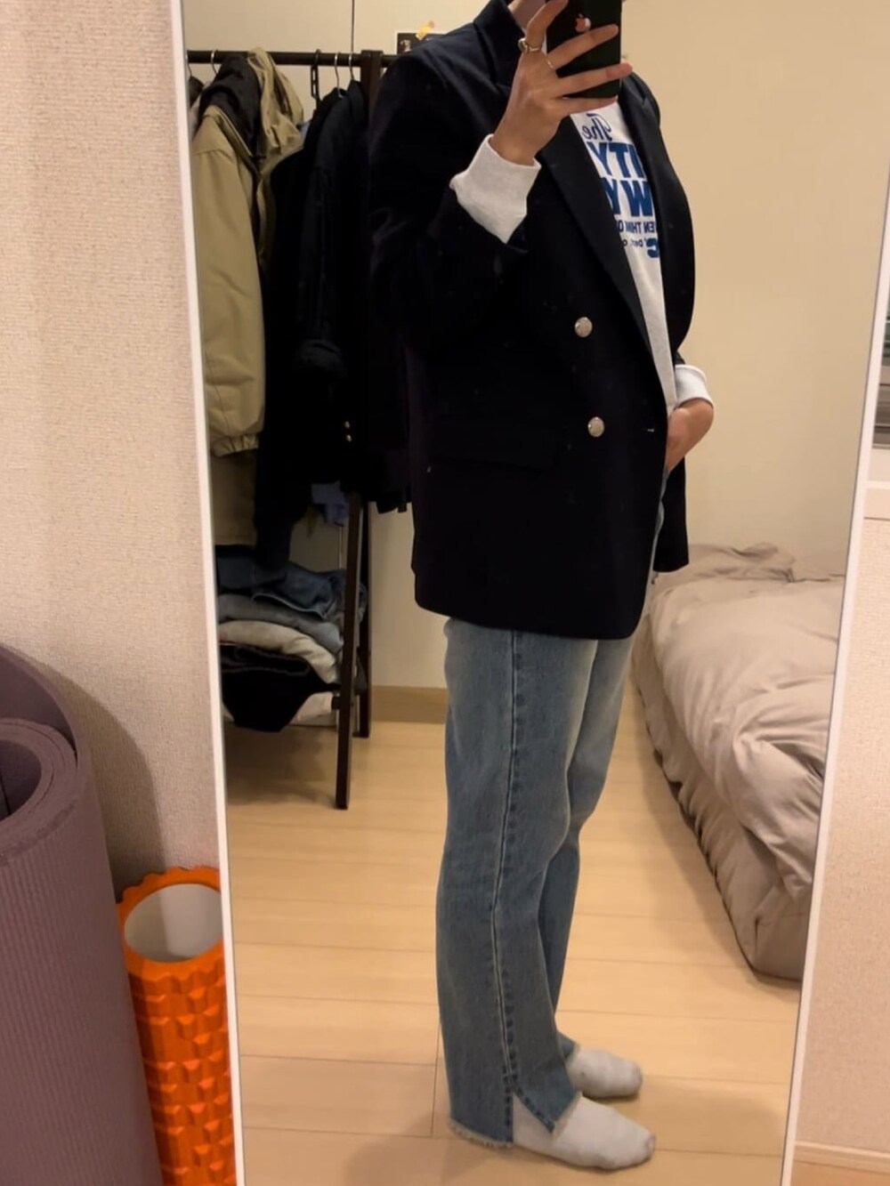 グレー系のスウェット、ブルー系のデニムパンツ、ベージュ系のテーラードジャケットを着用したレディースの冬コーディネートの2枚目の写真