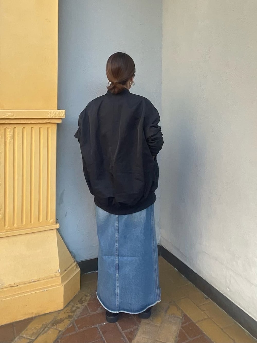 ホワイト系のニット/セーター、ブルー系のデニムスカート、ブラック系のブーツを着用したレディースの秋コーディネートの4枚目の写真