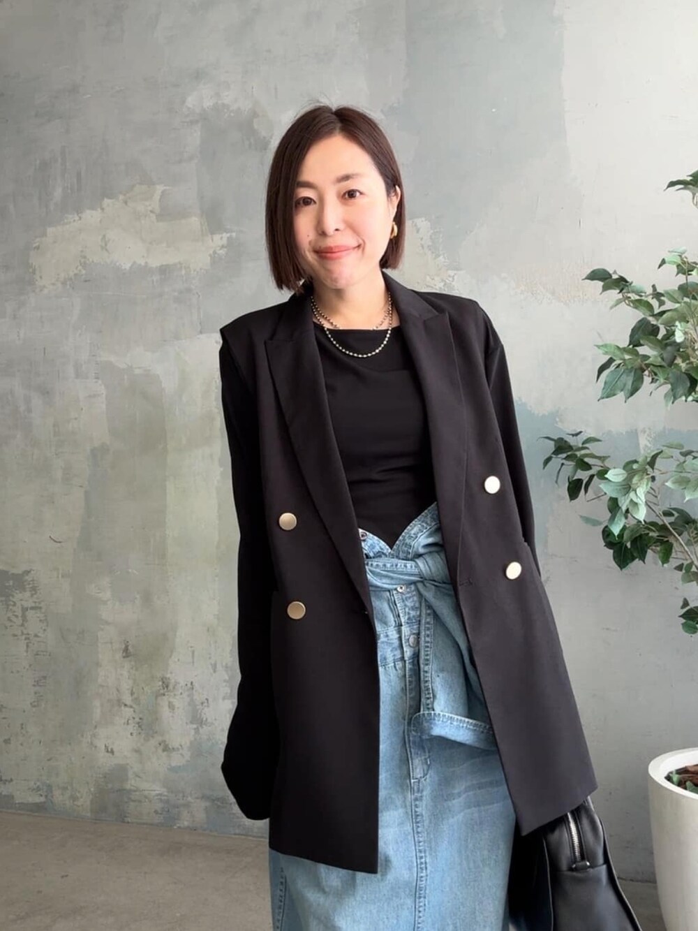 ブラック系のTシャツ/カットソー、ブラック系のベスト、ブルー系のシャツワンピースを着用したレディースの冬コーディネートの4枚目の写真