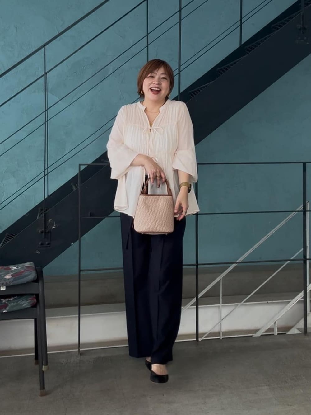 ホワイト系のシャツ/ブラウス、ブラウン系のハンドバッグ、ブルー系のチノパンツを着用したレディースの春コーディネートの4枚目の写真