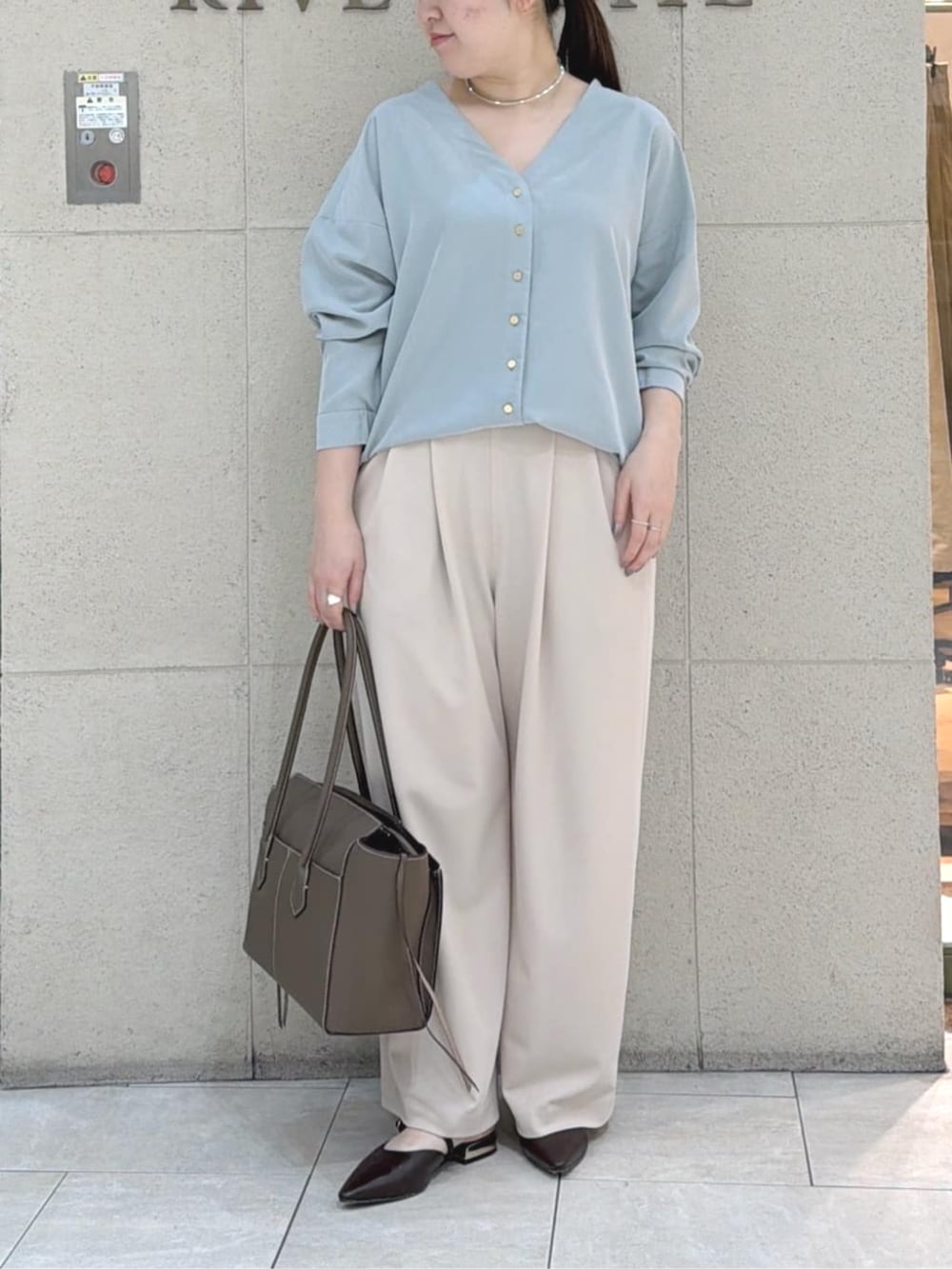 ブラウン系のその他シューズ、ブラウン系のトートバッグ、グリーン系のシャツ/ブラウスを着用したレディースの春コーディネートの2枚目の写真