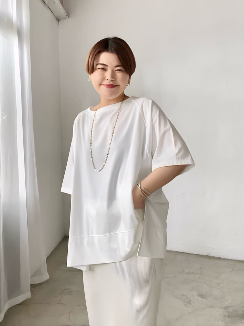 ブラック系のTシャツ/カットソー、ホワイト系のスカート、シルバー系のサンダルを着用したレディースの春コーディネートの4枚目の写真