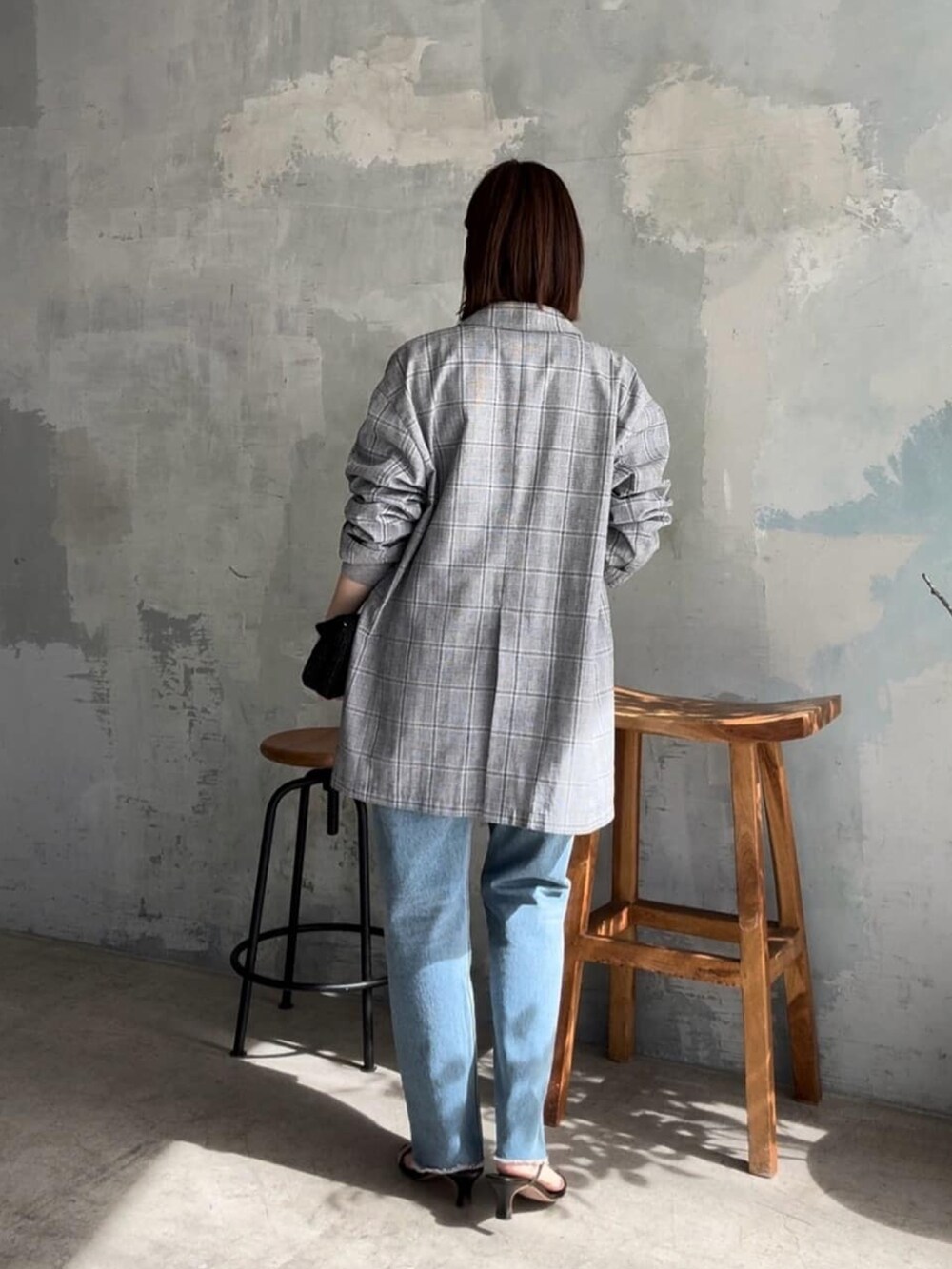 グレー系のテーラードジャケット、ブラック系のショルダーバッグ、ブルー系のデニムパンツを着用したレディースの春コーディネートの3枚目の写真