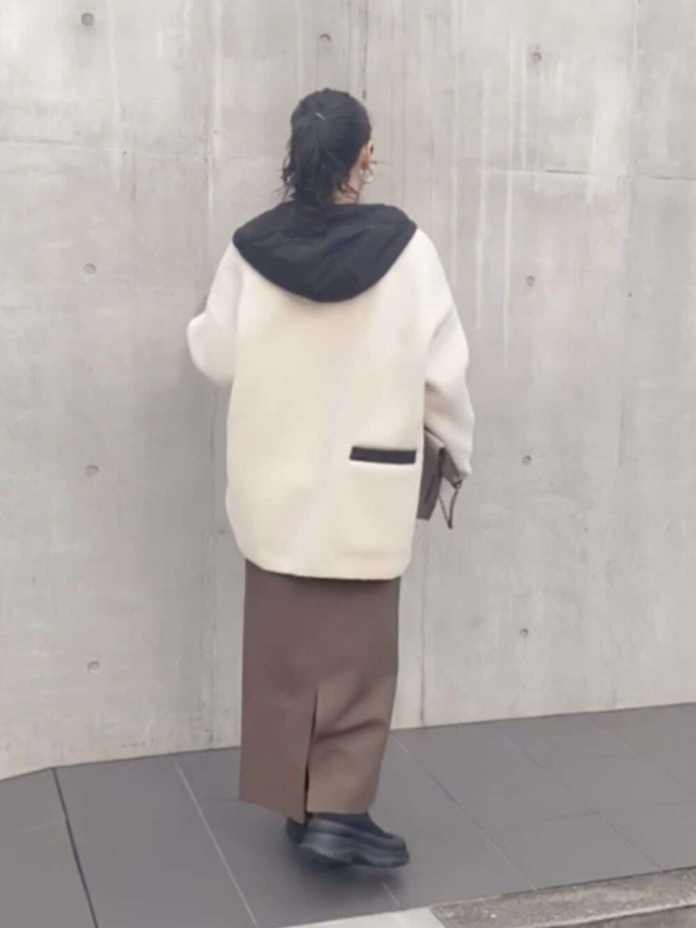 グレー系のスウェット、ブラウン系のスカート、ブラック系のブーツを着用したレディースの秋コーディネートの3枚目の写真