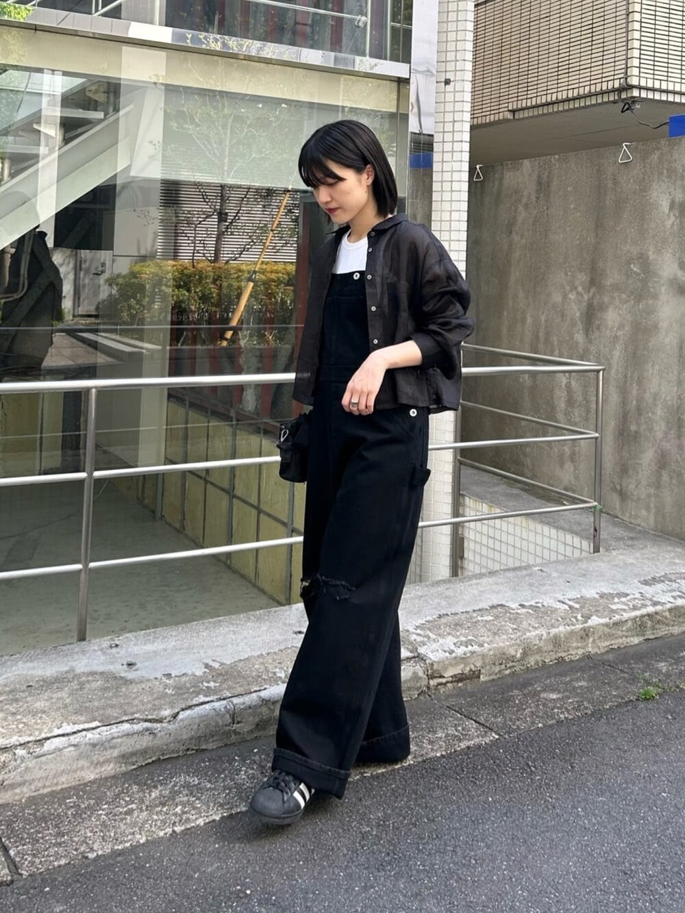 ブラック系のシャツ/ブラウス、ブラック系のサロペット/オーバーオールを着用したレディースの春コーディネートの2枚目の写真