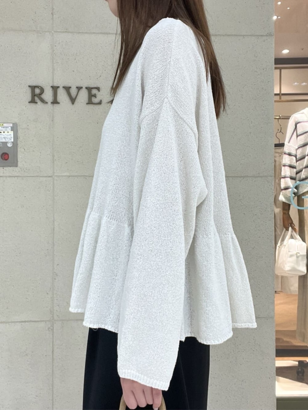 ベージュ系のトートバッグ、ブラウン系のその他シューズ、ホワイト系のニット/セーターを着用したレディースの春コーディネートの5枚目の写真