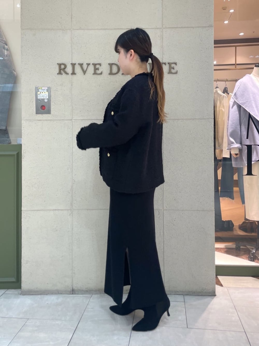 ブラック系のその他アウター、ブラック系のワンピース、ブラック系のハンドバッグを着用したレディースの冬コーディネートの3枚目の写真