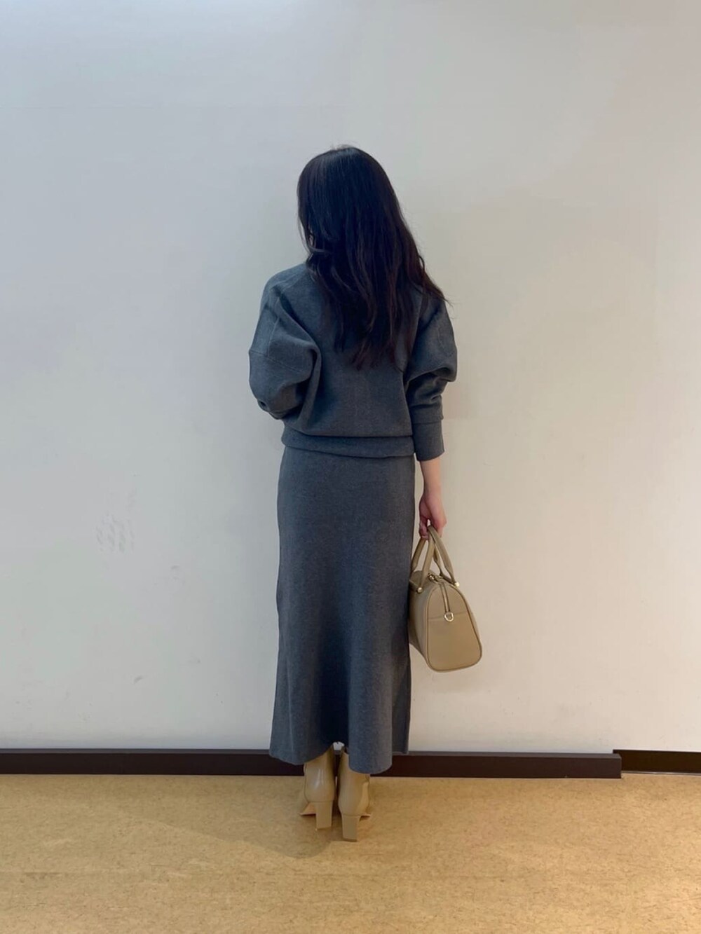 グレー系のカーディガン/ボレロ、グレー系のスカート、ベージュ系のブーツを着用したレディースの秋コーディネートの4枚目の写真