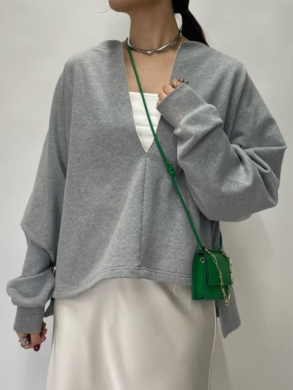 グレー系のスウェット、グリーン系のショルダーバッグ、ベージュ系のスカートを着用したレディースの冬コーディネートの4枚目の写真