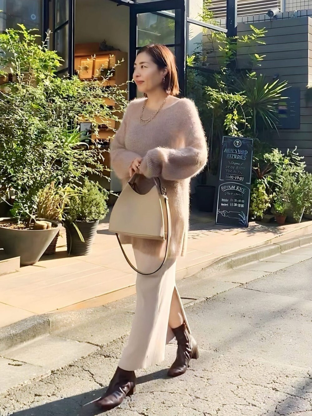 ベージュ系のスカート、ブラック系のブーツ、ベージュ系のニット/セーターを着用したレディースの秋コーディネートの4枚目の写真