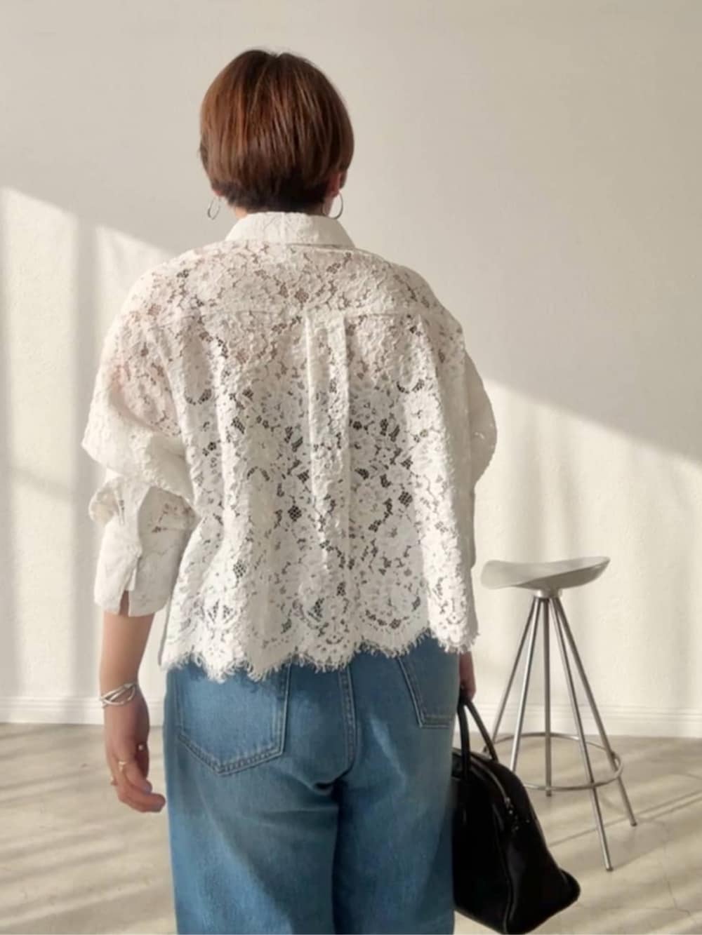 ブラック系のボストンバッグ、ブルー系のデニムパンツ、ベージュ系のその他シューズを着用したレディースの春コーディネートの4枚目の写真