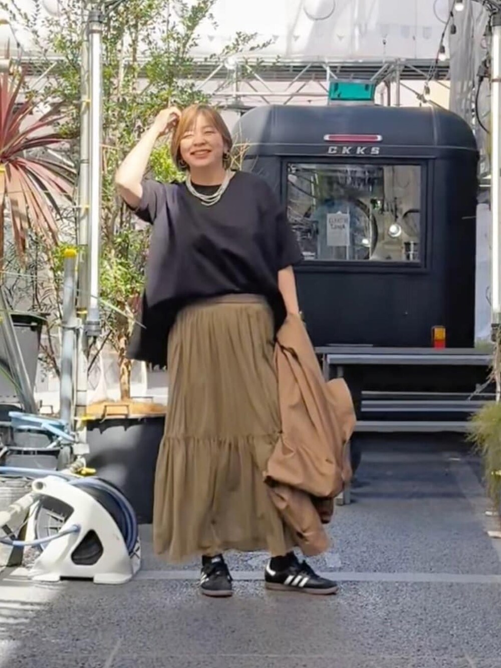 グレー系のスカート、ホワイト系のTシャツ/カットソーを着用したレディースの春コーディネートの3枚目の写真