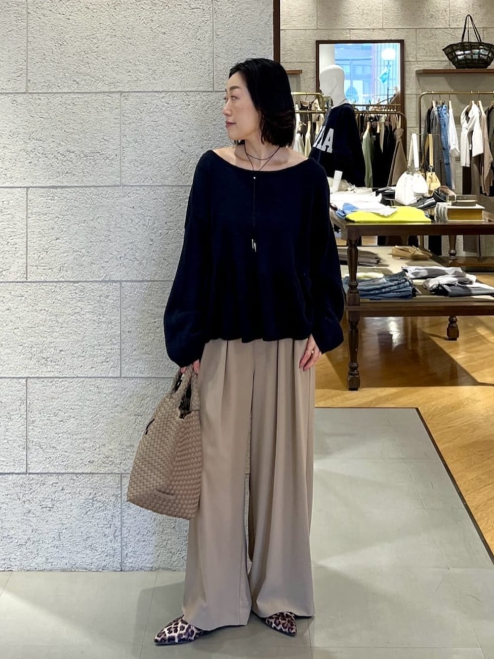 ベージュ系のその他シューズ、イエロー系のスラックス、ブラック系のニット/セーターを着用したレディースの春コーディネートの2枚目の写真