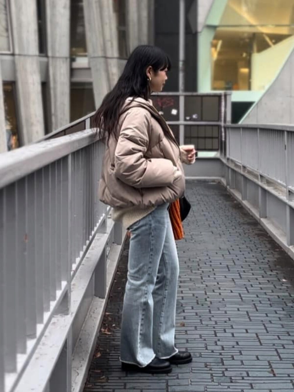 ブラック系のダウンジャケット/コート、ブルー系のデニムパンツ、ブラック系のブーツを着用したレディースの冬コーディネートの2枚目の写真