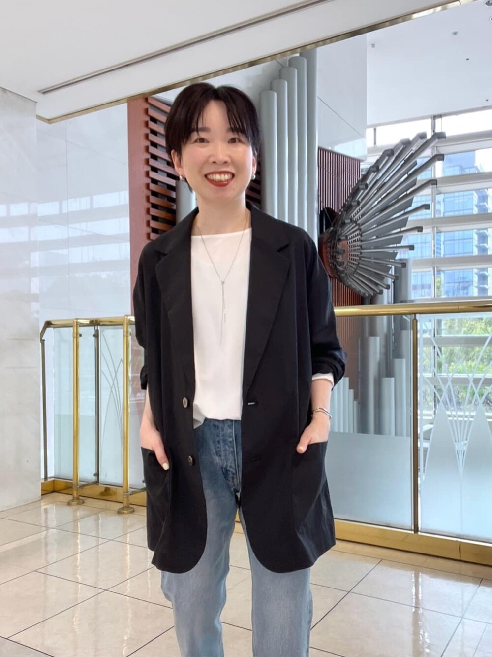 グリーン系のテーラードジャケット、ホワイト系のシャツ/ブラウス、ブラック系のサンダルを着用したレディースの春コーディネートの4枚目の写真