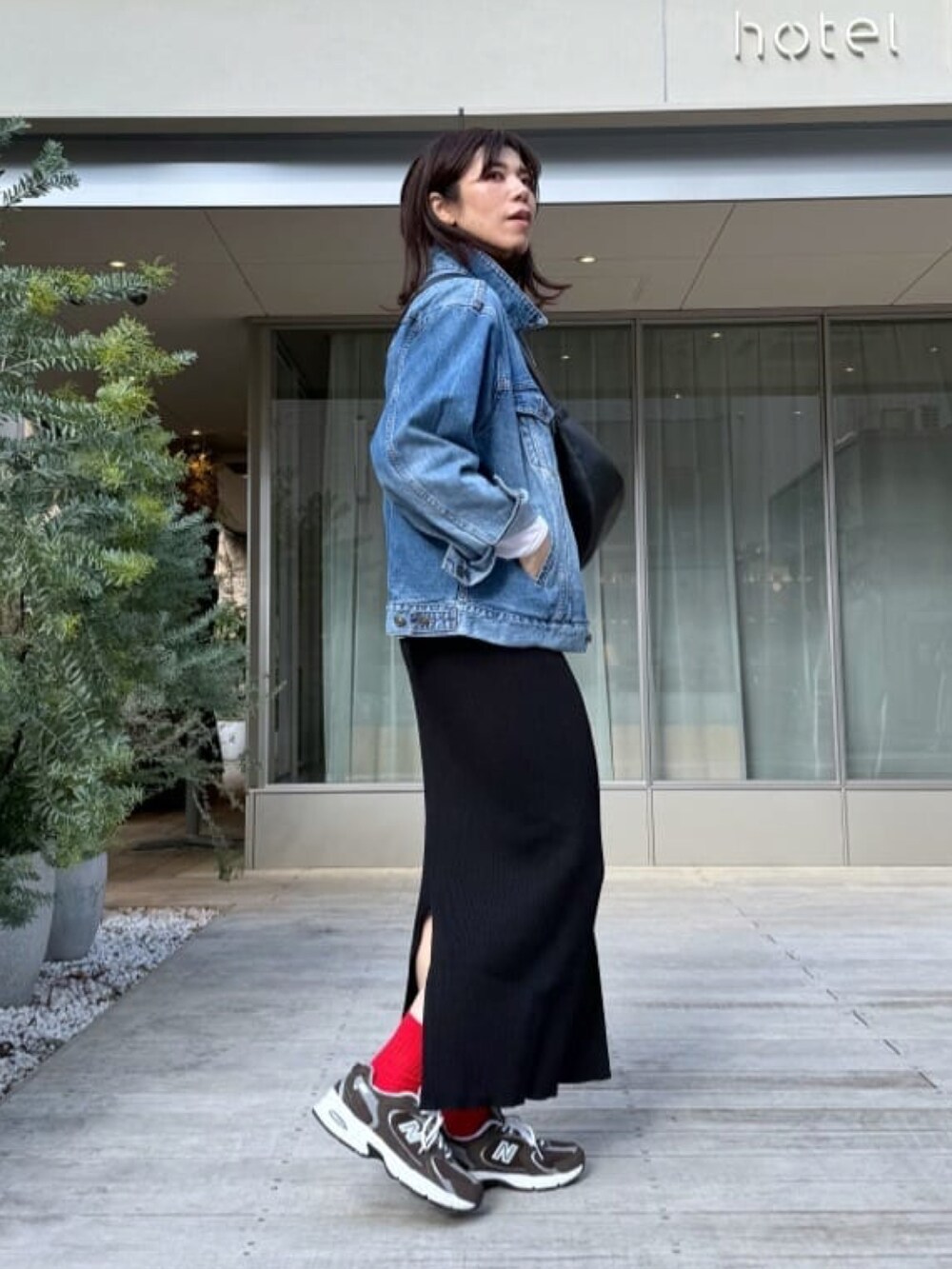 ブラック系のボディバッグ/ウエストポーチ、ブルー系のデニムジャケット、ブラック系のスカートを着用したレディースの冬コーディネートの3枚目の写真