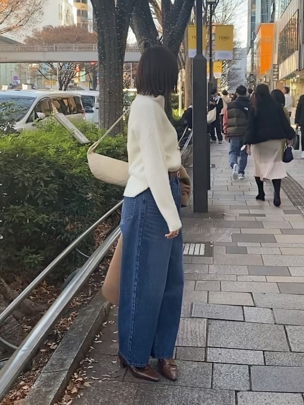 ブルー系のデニムパンツ、ホワイト系のニット/セーター、ブラウン系のローファーを着用したレディースの冬コーディネートの2枚目の写真