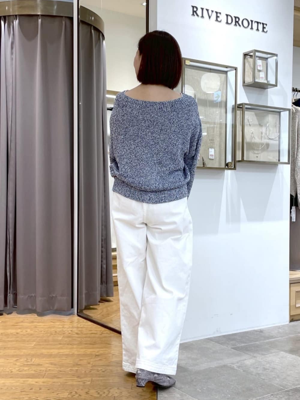 イエロー系のボストンバッグ、ホワイト系のデニムパンツ、ブルー系のニット/セーターを着用したレディースの春コーディネートの3枚目の写真