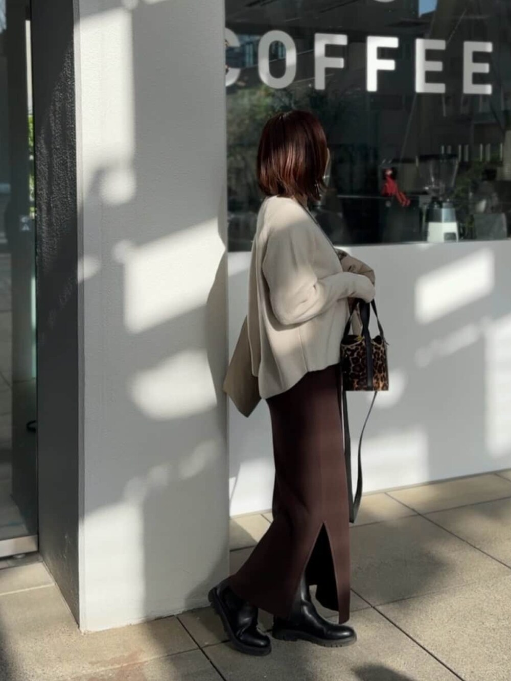 ホワイト系のニット/セーター、ブラウン系のワンピースを着用したレディースの冬コーディネートの4枚目の写真