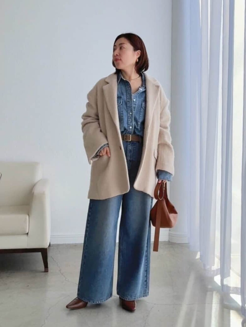 ブルー系のシャツ/ブラウス、ブラウン系のローファー、ブルー系のデニムパンツを着用したレディースの冬コーディネートの3枚目の写真