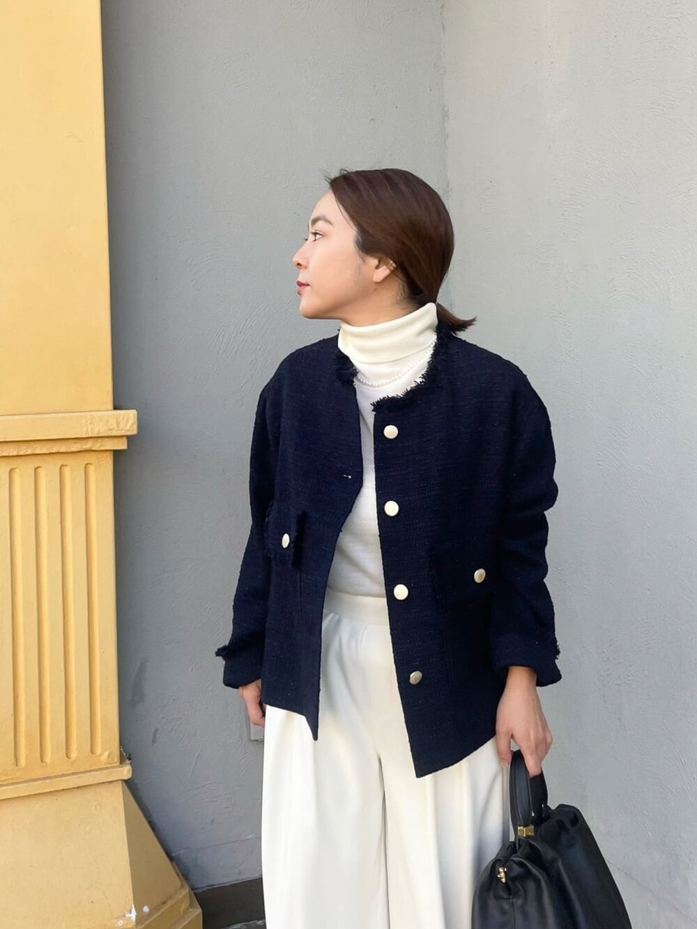 ブルー系のノーカラージャケット、ホワイト系のスラックス、ホワイト系のニット/セーターを着用したレディースの冬コーディネートの4枚目の写真