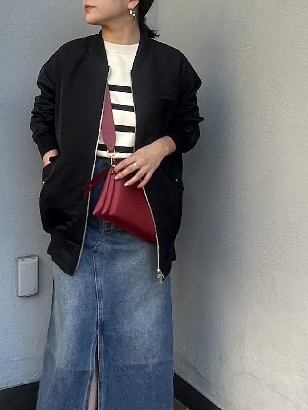 ホワイト系のニット/セーター、ブルー系のデニムスカート、ブラック系のブーツを着用したレディースの秋コーディネートの5枚目の写真