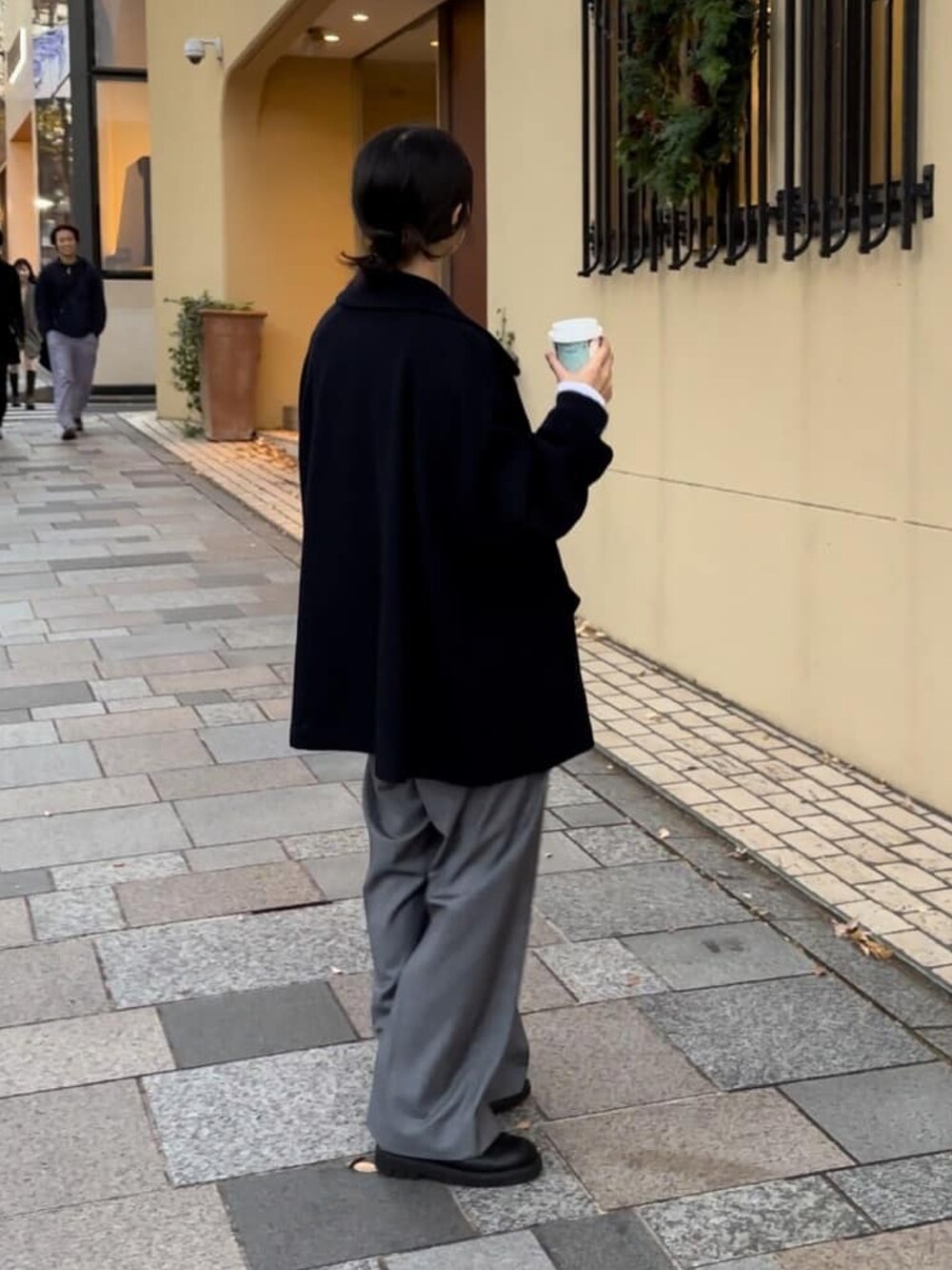ブルー系のピーコート、グレー系のその他パンツ、ブラック系のブーツを着用したレディースの冬コーディネートの3枚目の写真