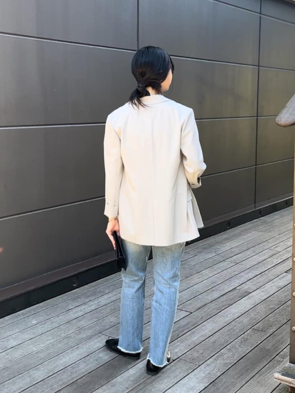 ホワイト系のTシャツ/カットソー、グレー系のテーラードジャケット、ブルー系のデニムパンツを着用したレディースの冬コーディネートの3枚目の写真