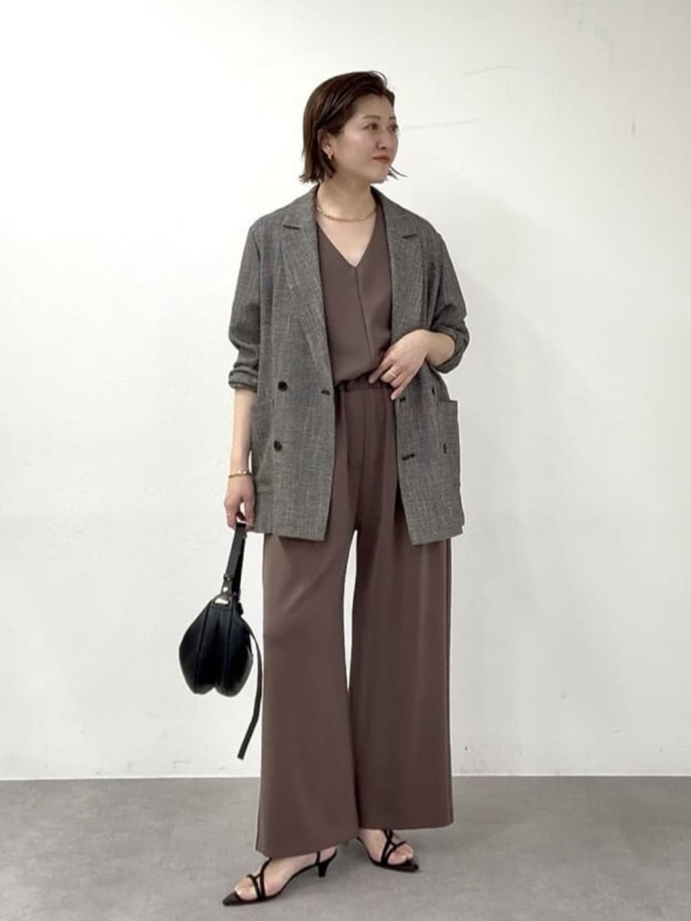 ベージュ系のその他シューズ、ゴールド系のショルダーバッグ、ブラウン系のその他パンツを着用したレディースの春コーディネートの6枚目の写真