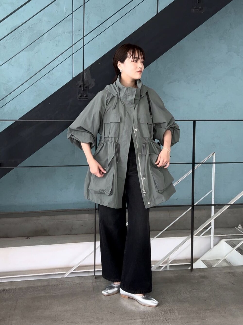 グリーン系のマウンテンパーカー、ブラック系のデニムパンツを着用したレディースの夏コーディネートの3枚目の写真